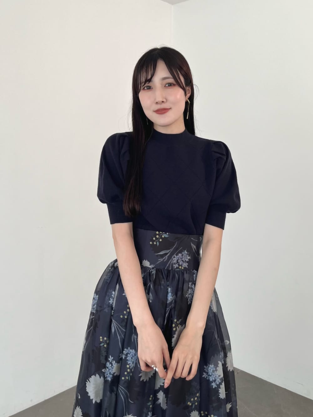 ブラウン系のブーツ、ブルー系のニット/セーター、グレー系のスカートを着用したレディースの夏コーディネートの6枚目の写真