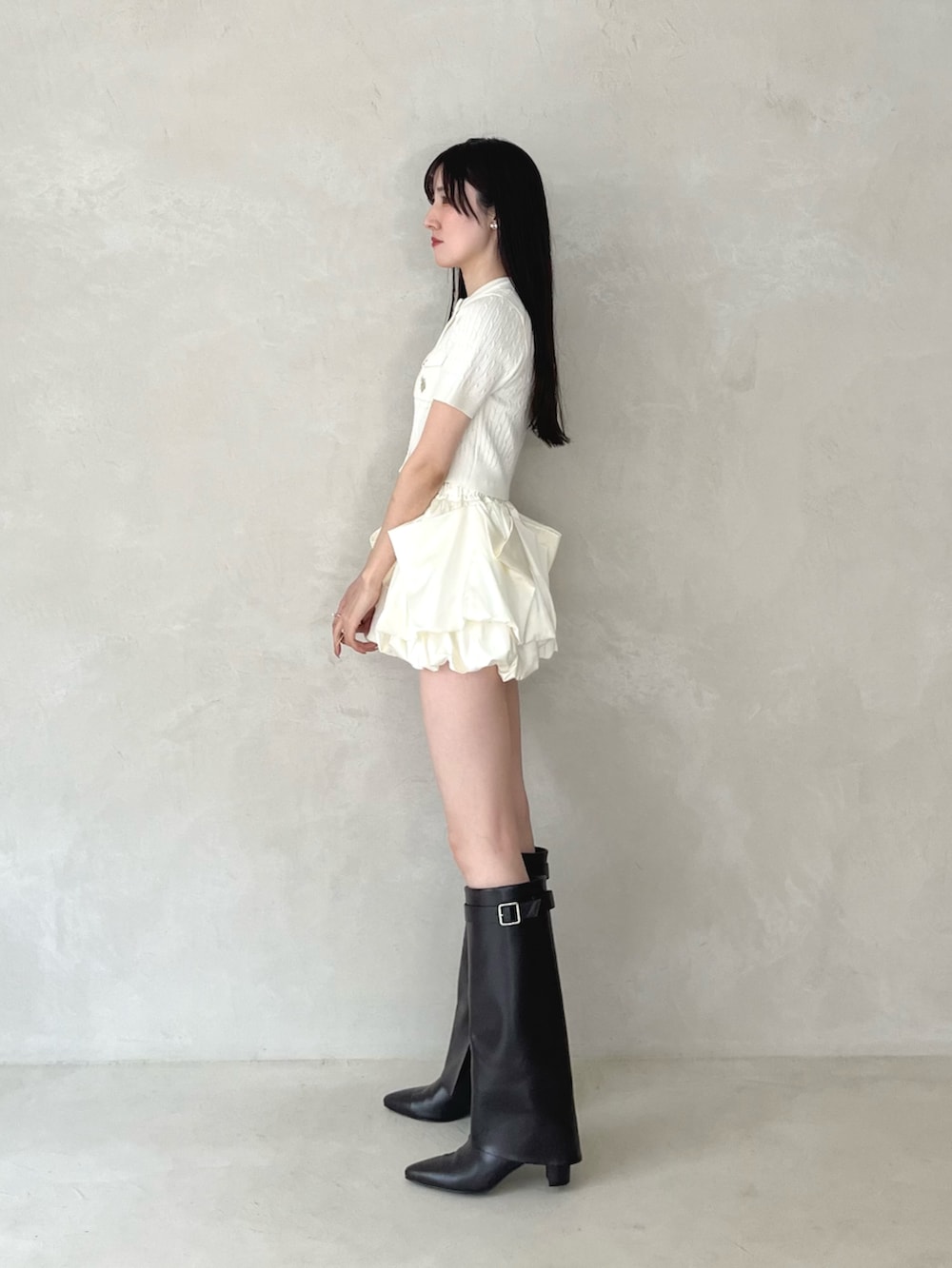 ブラウン系のブーツ、ホワイト系のカーディガン/ボレロ、ホワイト系のスカートを着用したレディースの夏コーディネートの3枚目の写真