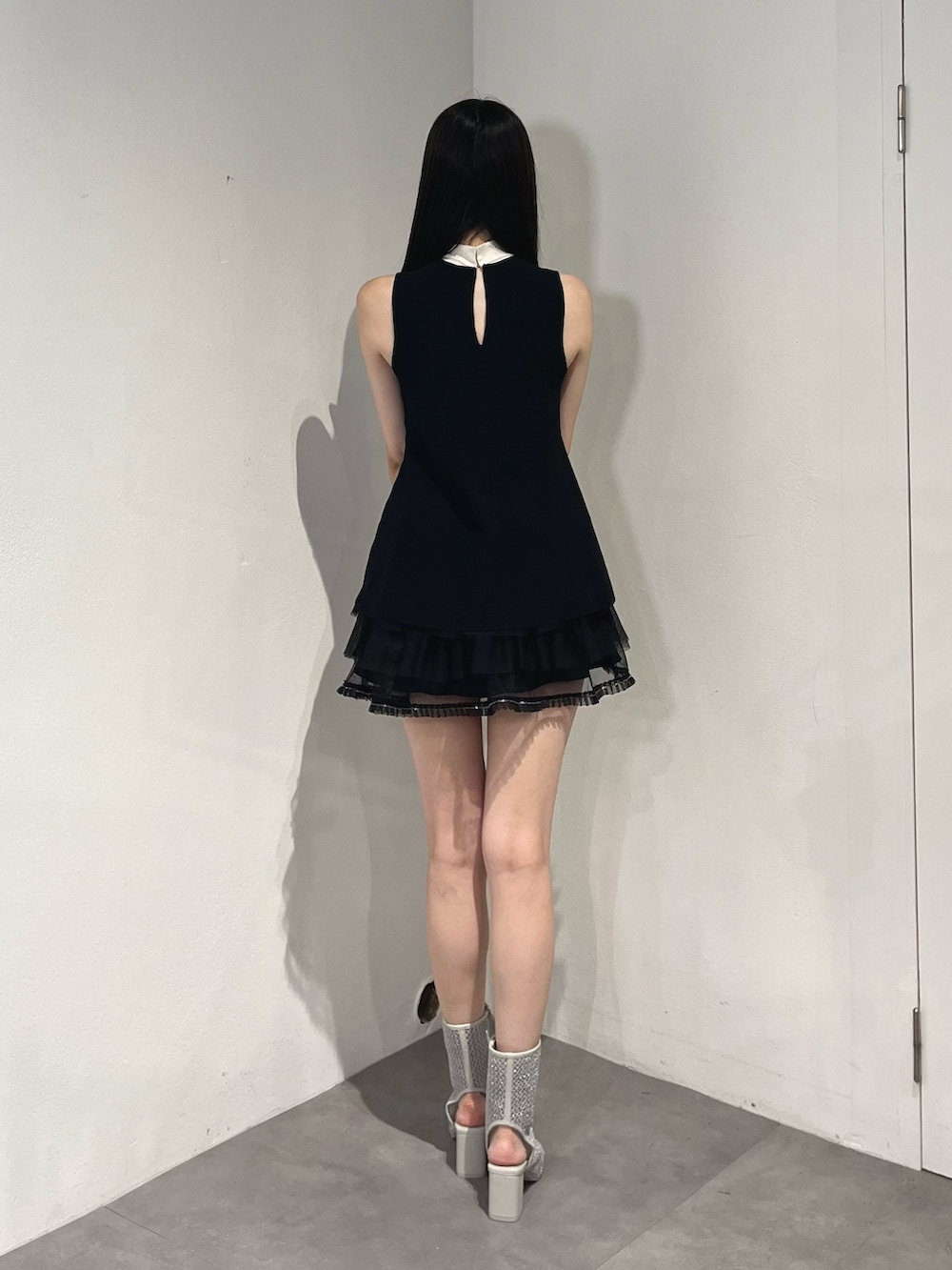 ブラック系のスカート、ブラック系のニット/セーター、グレー系のブーツを着用したレディースの夏コーディネートの4枚目の写真