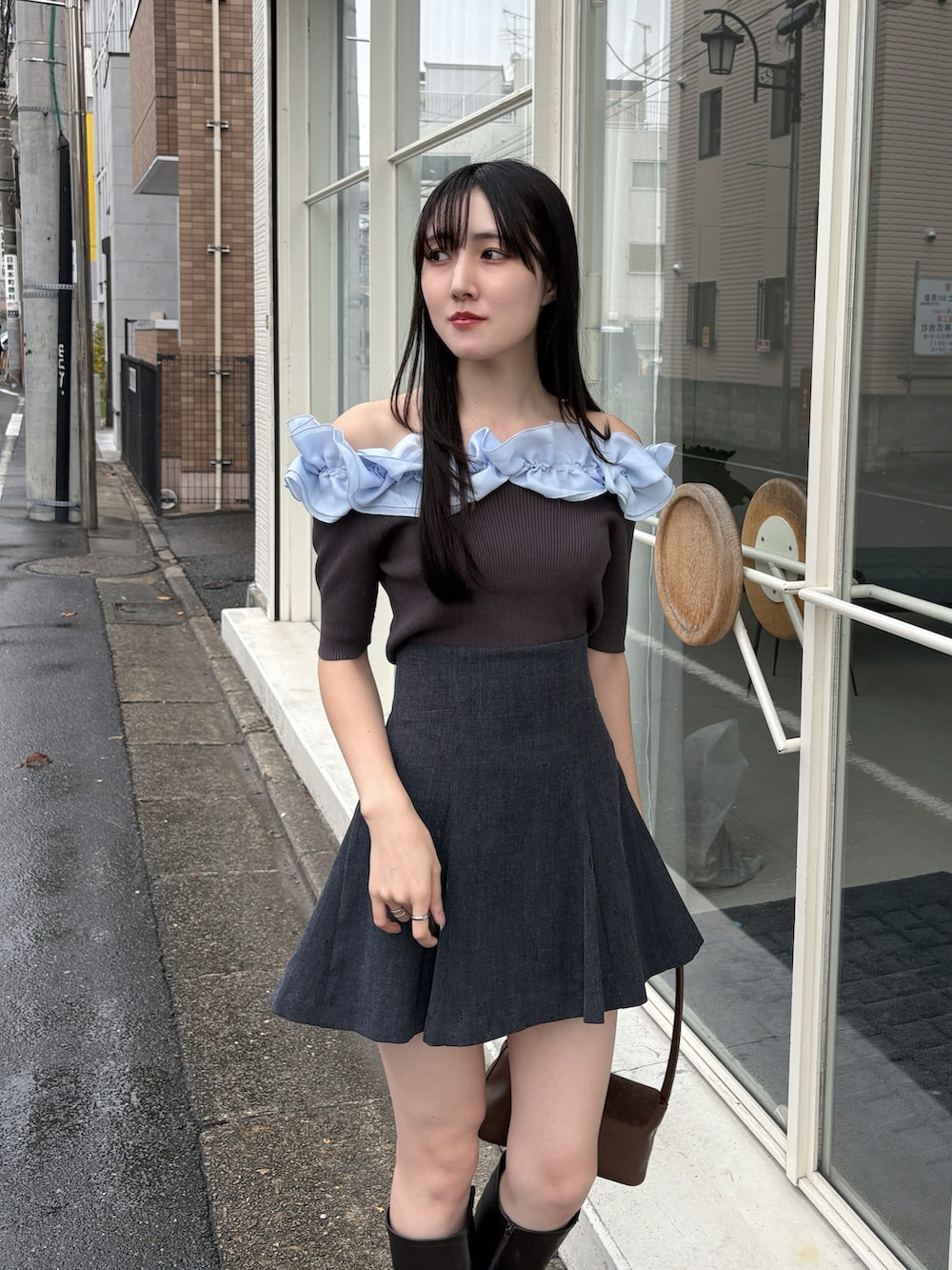 グレー系のニット/セーター、グレー系のスカート、ブラウン系のハンドバッグを着用したレディースの冬コーディネートの3枚目の写真