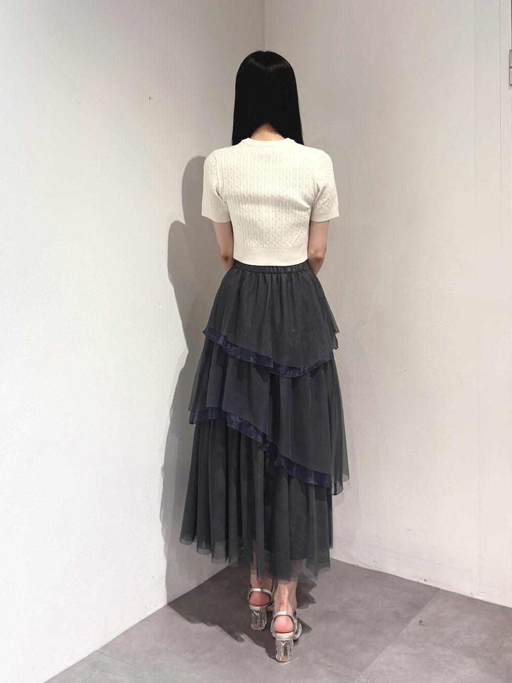グレー系のスカート、ホワイト系のカーディガン/ボレロ、シルバー系のサンダルを着用したレディースの夏コーディネートの4枚目の写真