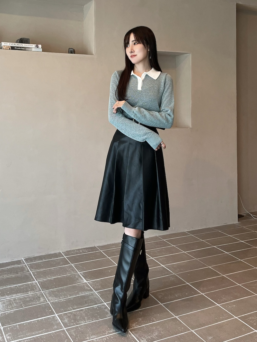 ブラック系のブーツ、ブラック系のスカート、ブルー系のニット/セーターを着用したレディースの秋コーディネートの3枚目の写真