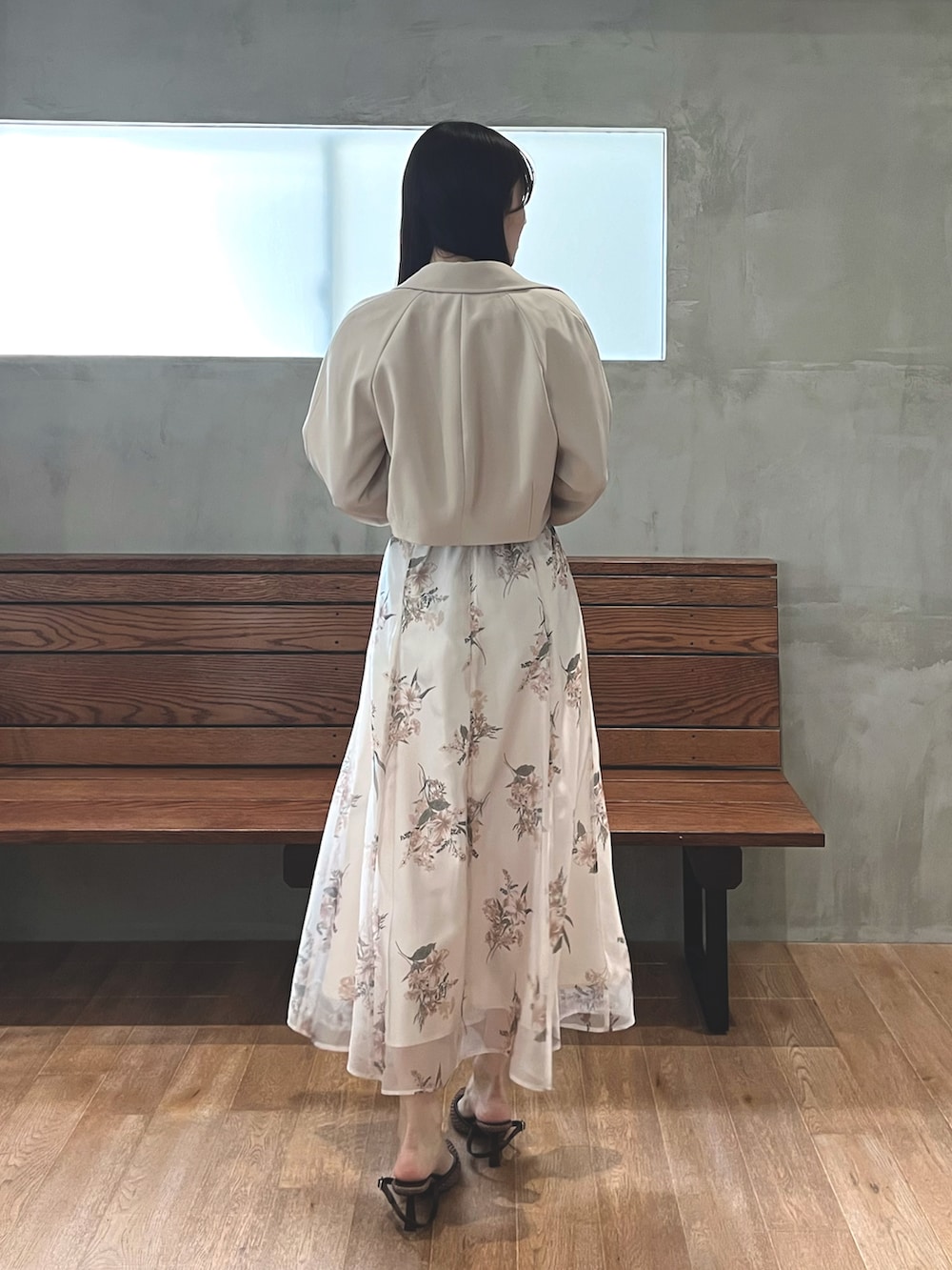ブラウン系のパンプス、ベージュ系のワンピース、ホワイト系のトレンチコートを着用したレディースの春コーディネートの3枚目の写真