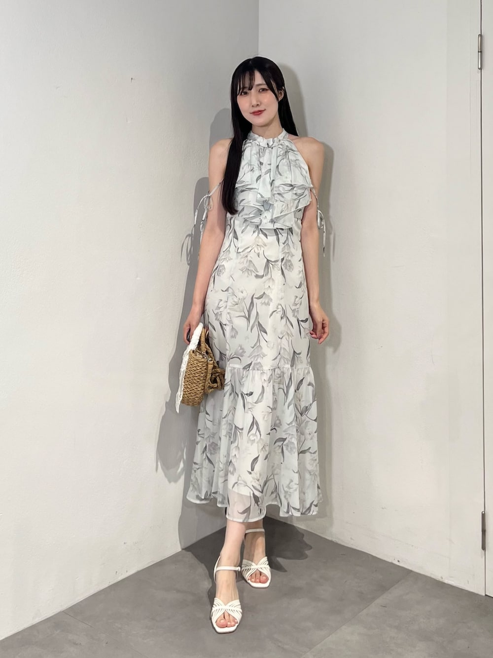 ブルー系のワンピース、ベージュ系のハンドバッグ、ホワイト系のサンダルを着用したレディースの夏コーディネートの2枚目の写真