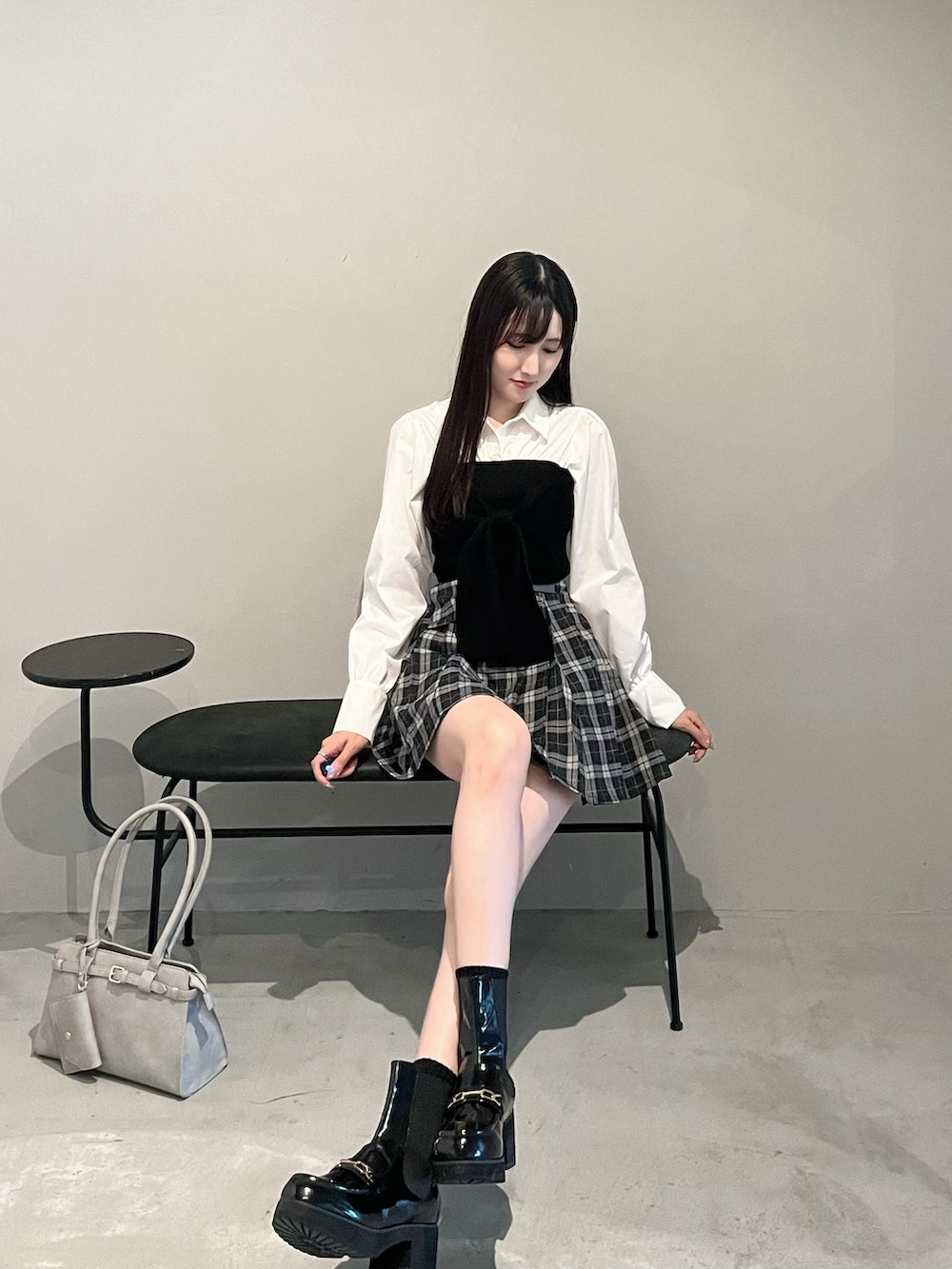 ブラック系のブーツ、その他のスカート、グレー系のハンドバッグを着用したレディースの秋コーディネートの3枚目の写真