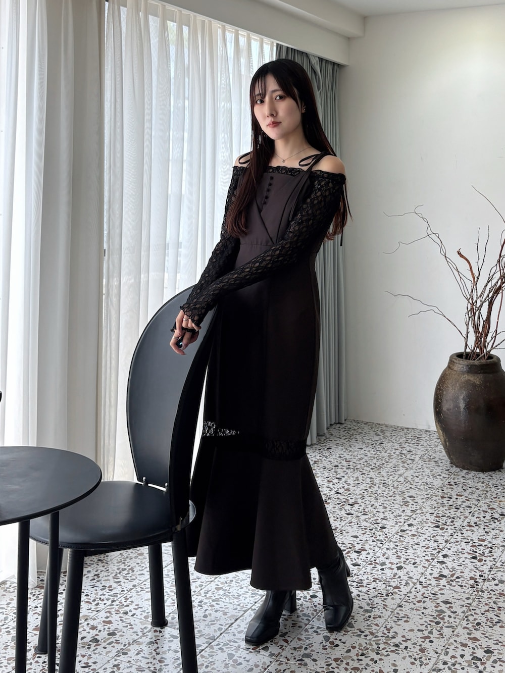 ブラウン系のワンピース、ブラック系のブーツを着用したレディースの冬コーディネートの2枚目の写真