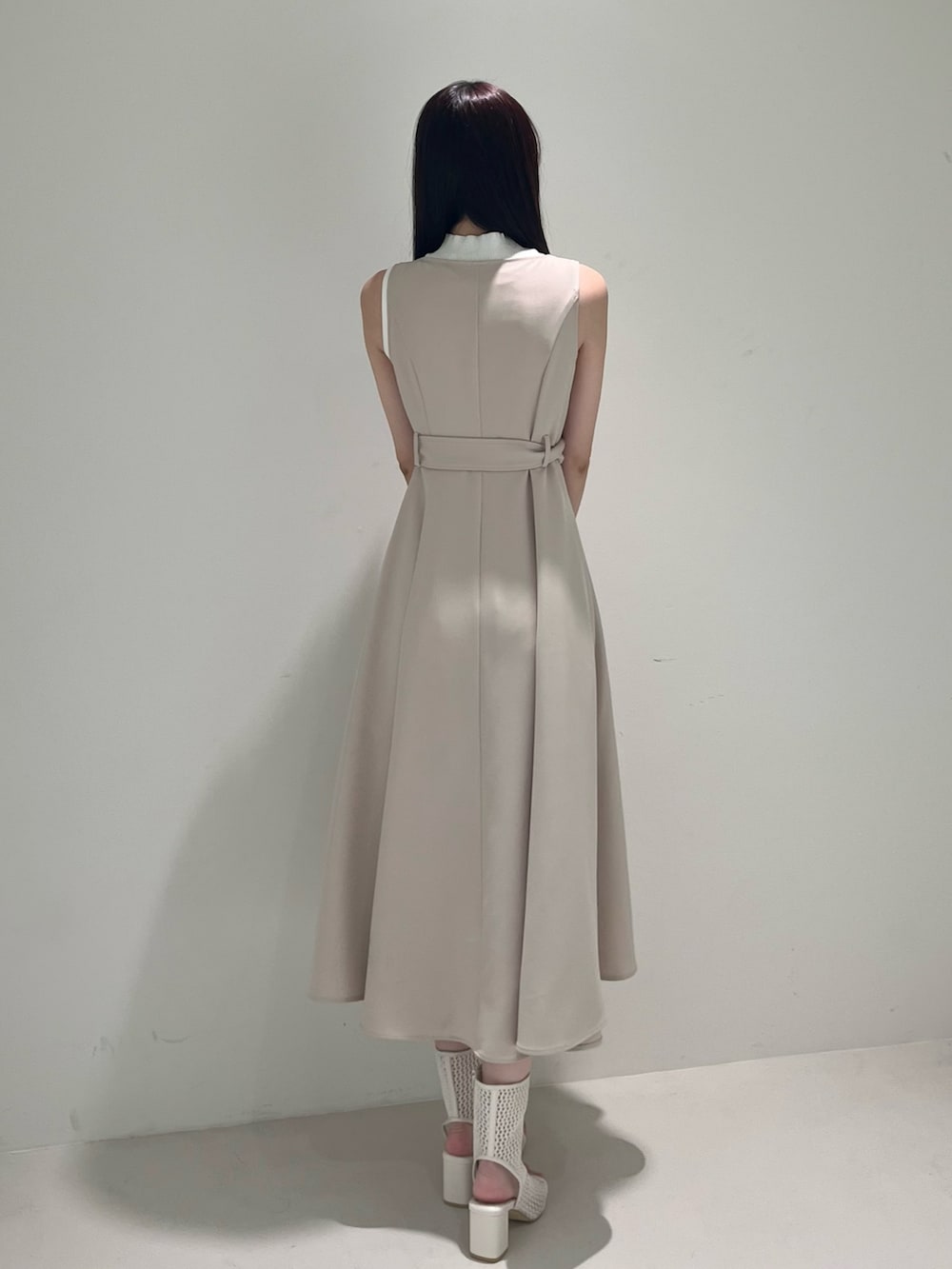 ベージュ系のワンピース、ホワイト系のブーツ、ホワイト系のニット/セーターを着用したレディースの春コーディネートの4枚目の写真