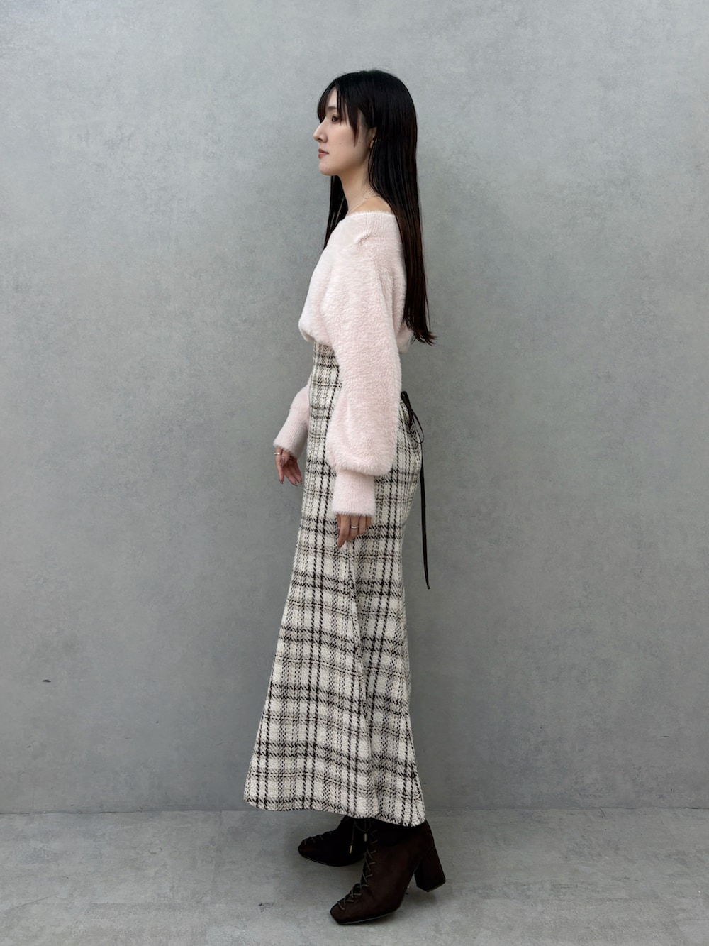 ブラウン系のブーツ、ホワイト系のスカート、ピンク系のニット/セーターを着用したレディースの冬コーディネートの3枚目の写真