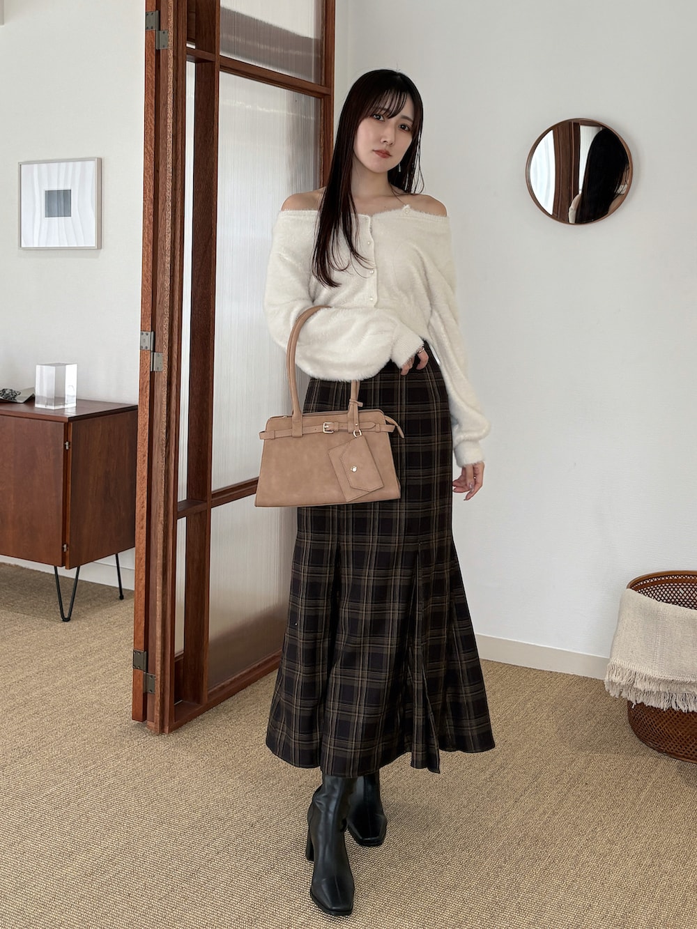 ホワイト系のカーディガン/ボレロ、ブラウン系のスカート、ベージュ系のハンドバッグを着用したレディースの秋コーディネートの2枚目の写真
