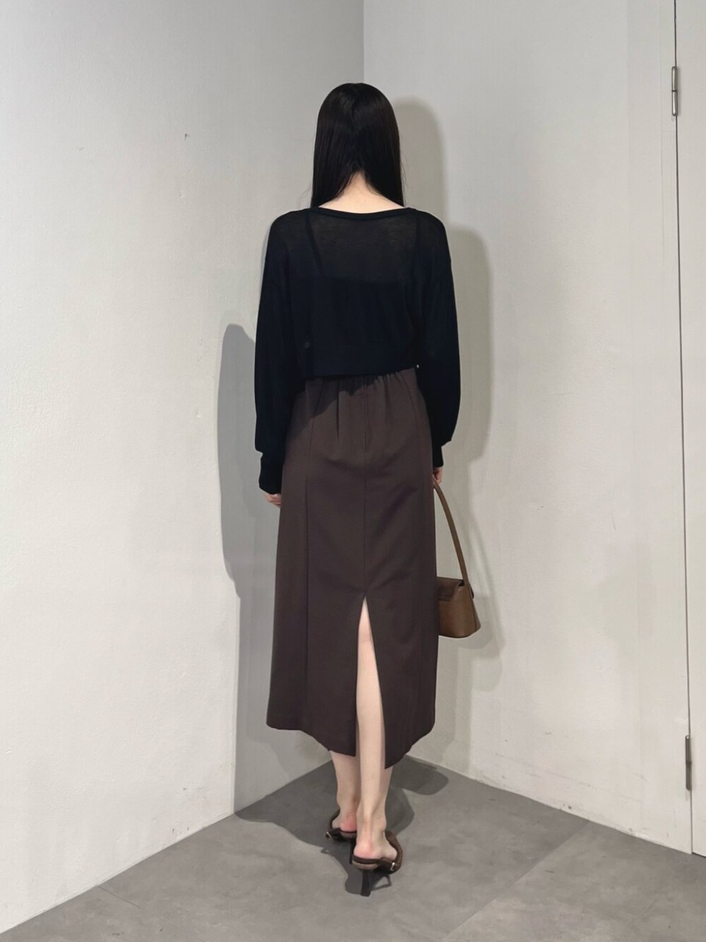 ブラウン系のハンドバッグ、ブラウン系のパンプス、ブラック系のカーディガン/ボレロを着用したレディースの夏コーディネートの4枚目の写真