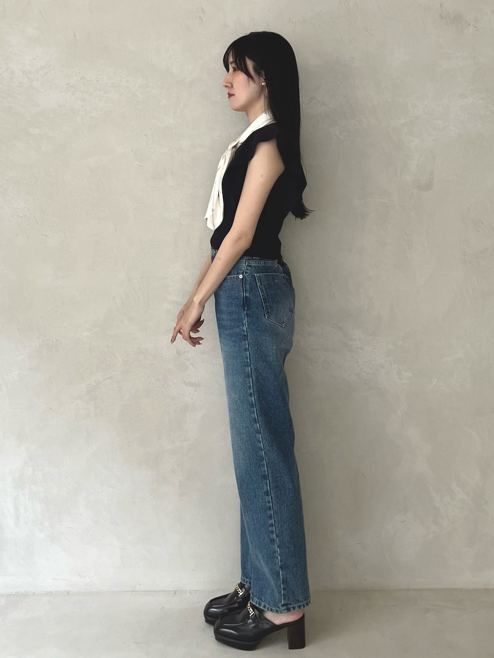 ブルー系のデニムパンツ、ブラウン系のシューズ、ブルー系のニット/セーターを着用したレディースの夏コーディネートの5枚目の写真