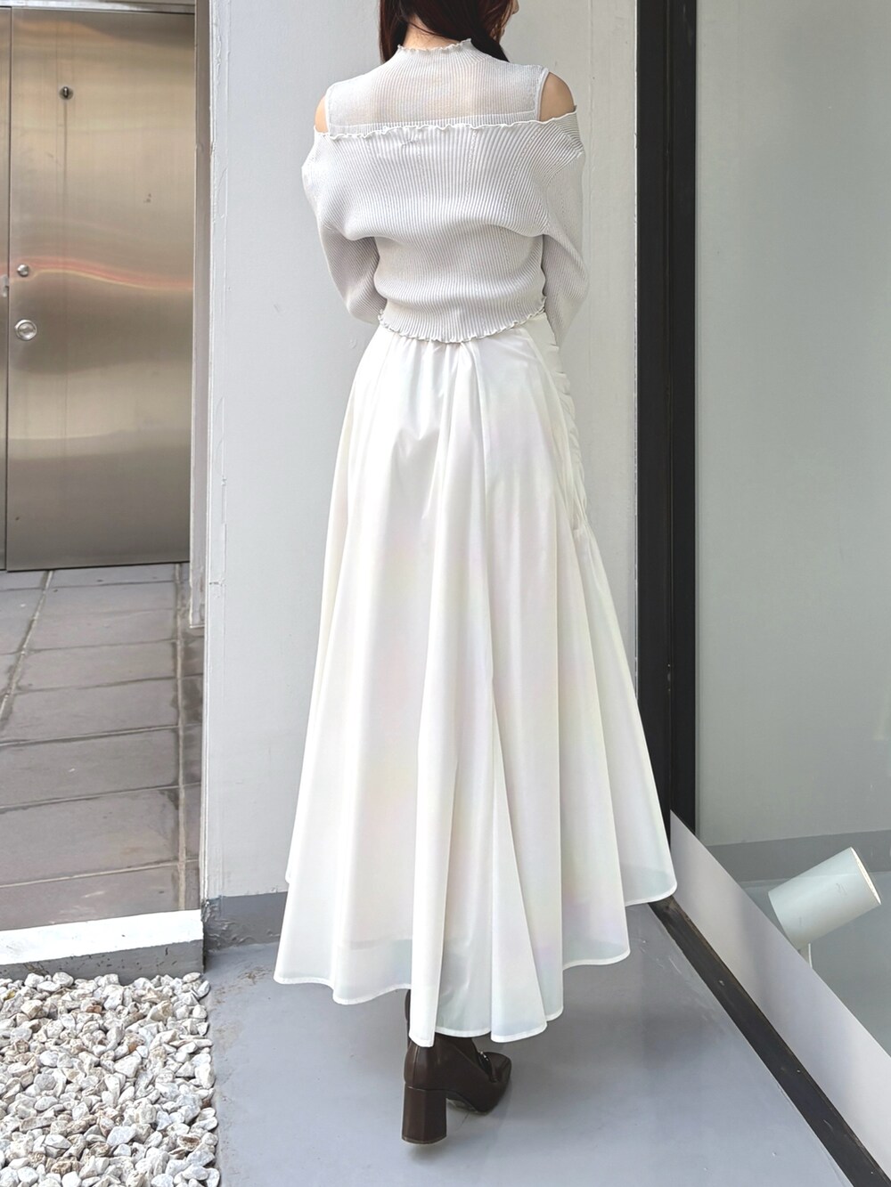 グレー系のカーディガン/ボレロ、グレー系のニット/セーター、ホワイト系のスカートを着用したレディースの冬コーディネートの4枚目の写真