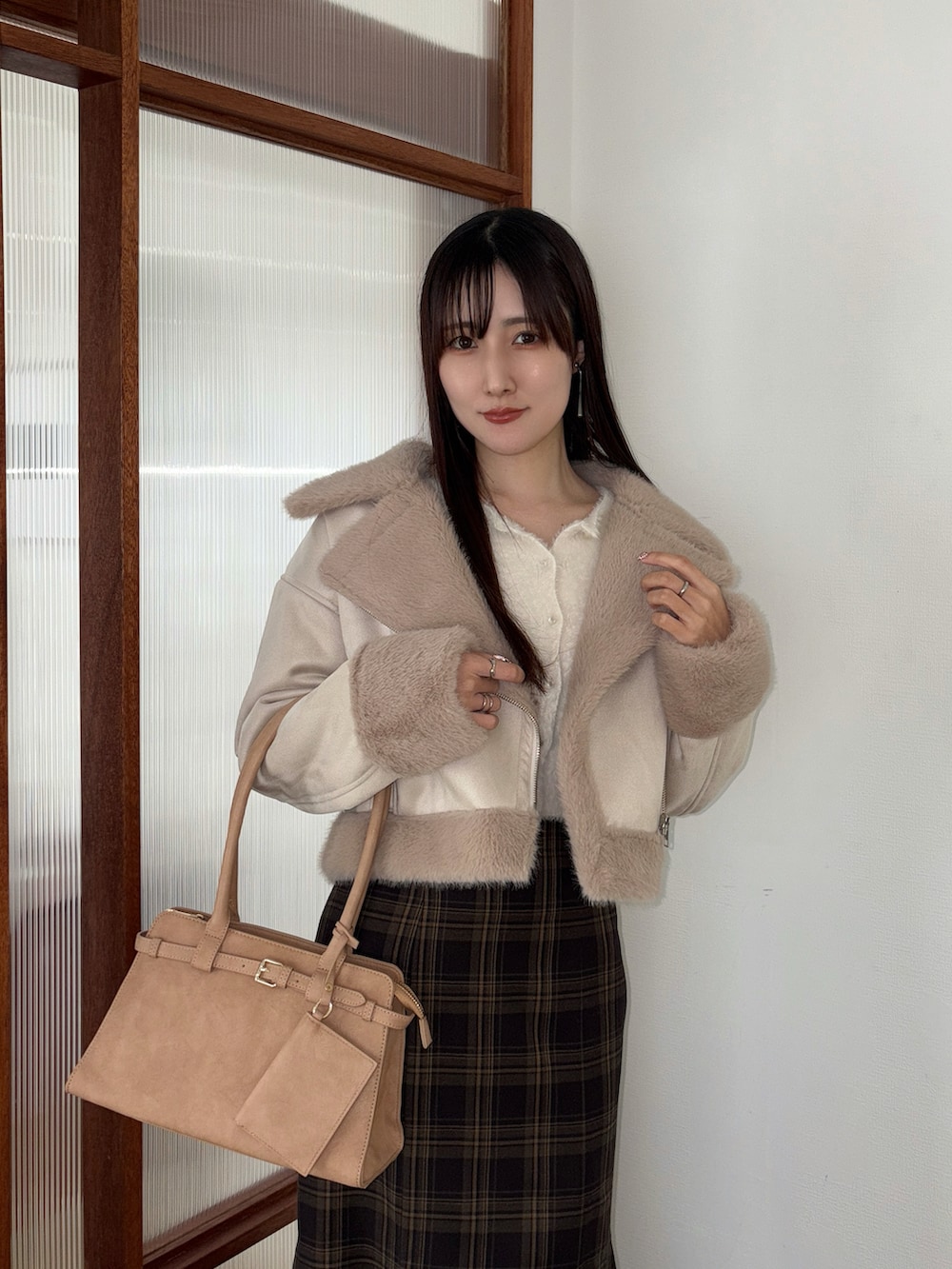 ホワイト系のカーディガン/ボレロ、ベージュ系のハンドバッグ、ブラック系のブーツを着用したレディースの冬コーディネートの4枚目の写真