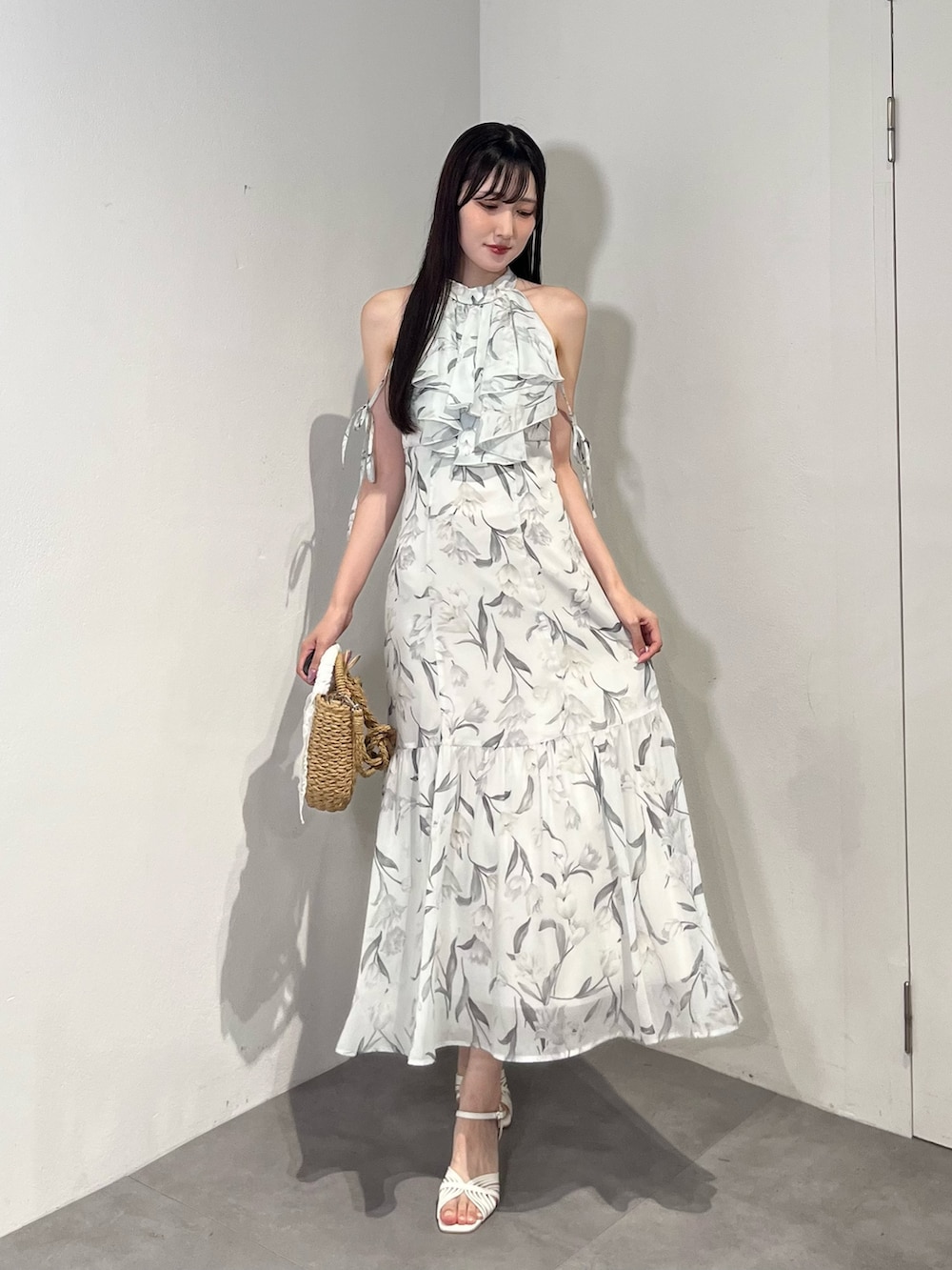 ブルー系のワンピース、ベージュ系のハンドバッグ、ホワイト系のサンダルを着用したレディースの夏コーディネートの3枚目の写真
