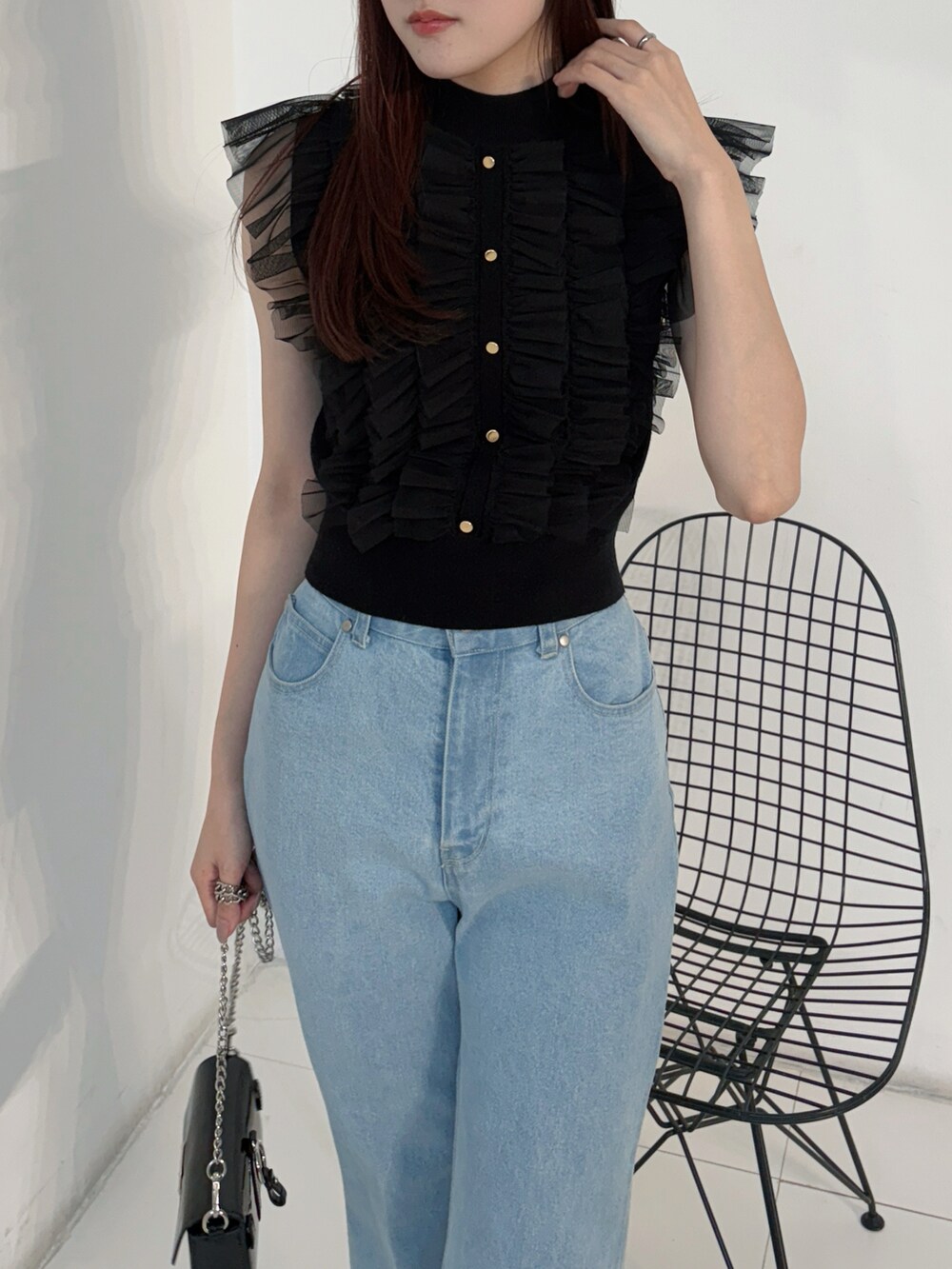 ブラック系のニット/セーター、ブルー系のデニムパンツ、ブラック系のボディバッグ/ウエストポーチを着用したレディースの春コーディネートの4枚目の写真