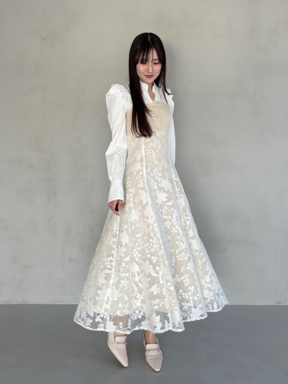 ホワイト系のパンプス、ベージュ系のワンピースを着用したレディースの冬コーディネートの3枚目の写真