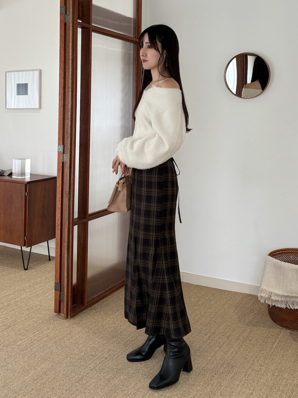 ホワイト系のカーディガン/ボレロ、ブラウン系のスカート、ベージュ系のハンドバッグを着用したレディースの秋コーディネートの3枚目の写真