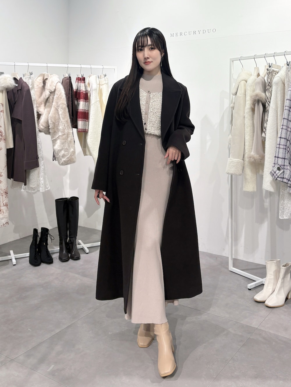 ブラウン系のチェスターコート、ピンク系のワンピース、ベージュ系のブーツを着用したレディースの冬コーディネートの3枚目の写真