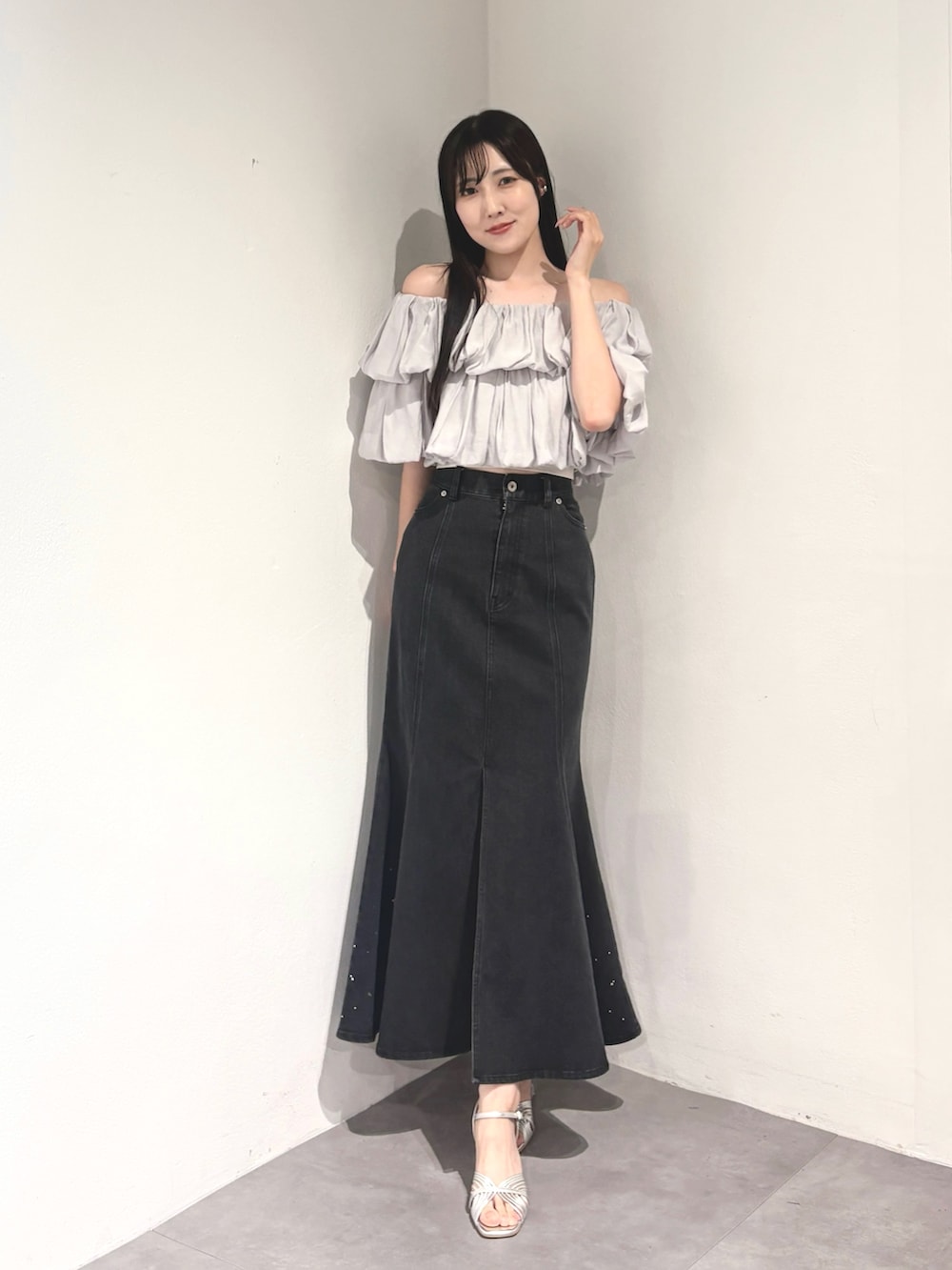 ブラック系のスカート、グレー系のシャツ/ブラウス、シルバー系のサンダルを着用したレディースの夏コーディネートの2枚目の写真