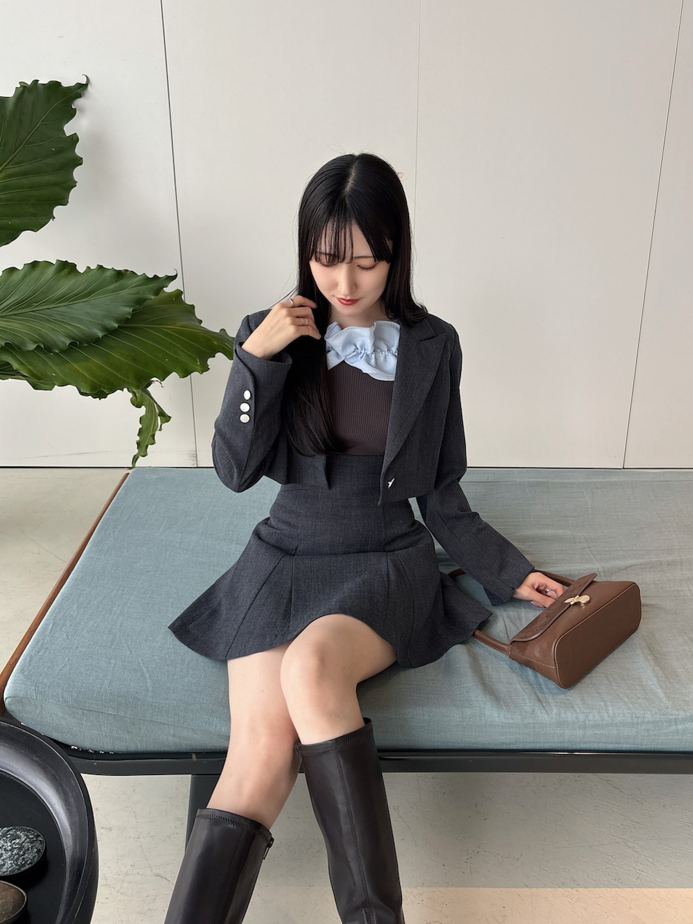 ブラウン系のブーツ、グレー系のテーラードジャケット、グレー系のスカートを着用したレディースの冬コーディネートの4枚目の写真