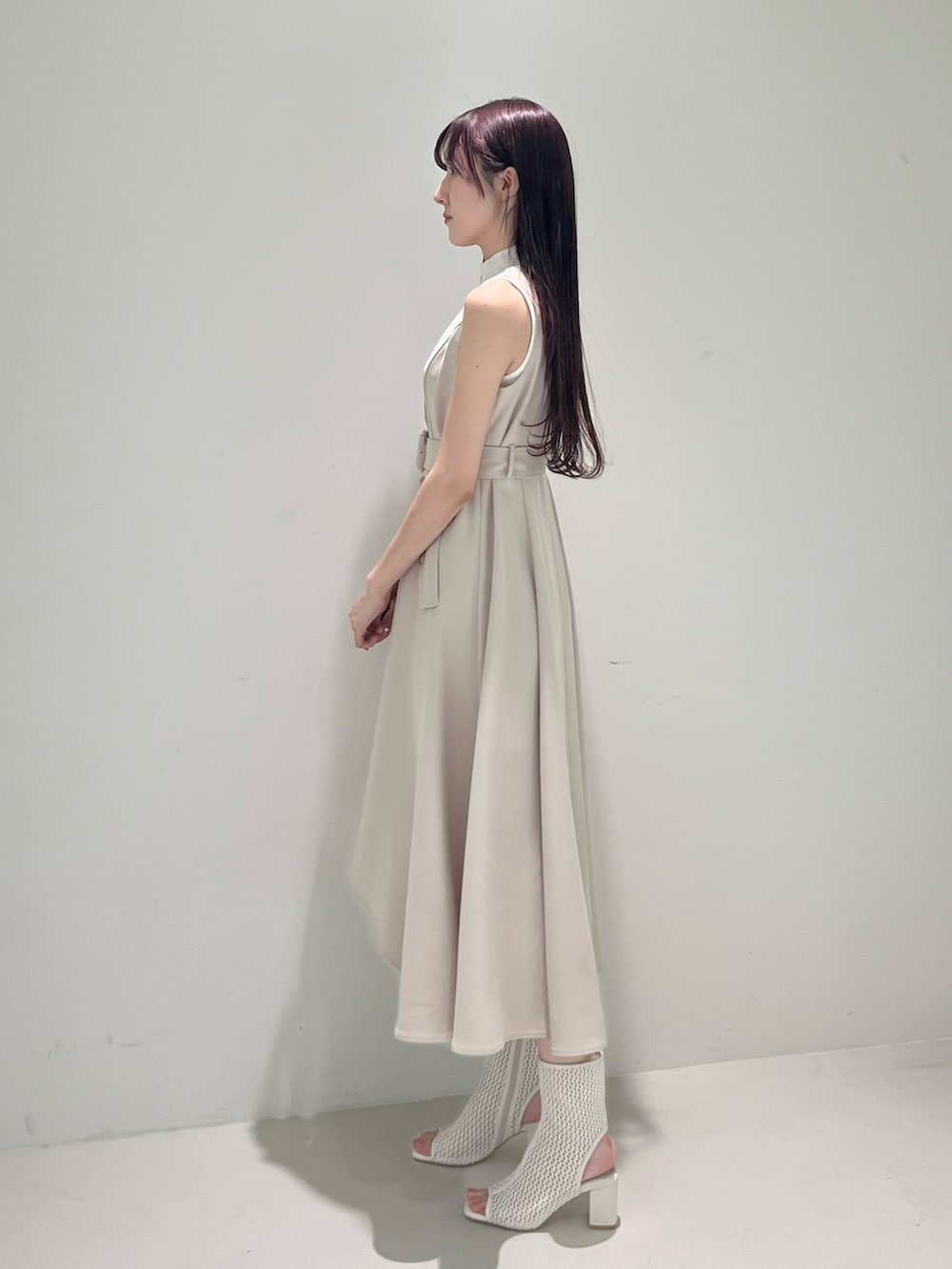 ベージュ系のワンピース、ホワイト系のブーツ、ホワイト系のニット/セーターを着用したレディースの春コーディネートの3枚目の写真