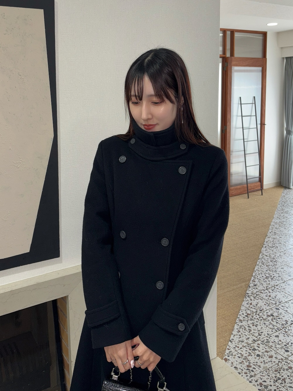 ブラック系のその他アウター、ブラック系のハンドバッグ、ブラック系のブーツを着用したレディースの冬コーディネートの5枚目の写真