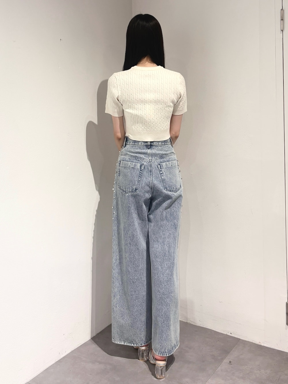 ブルー系のデニムパンツ、シルバー系のサンダル、ホワイト系のカーディガン/ボレロを着用したレディースの夏コーディネートの4枚目の写真