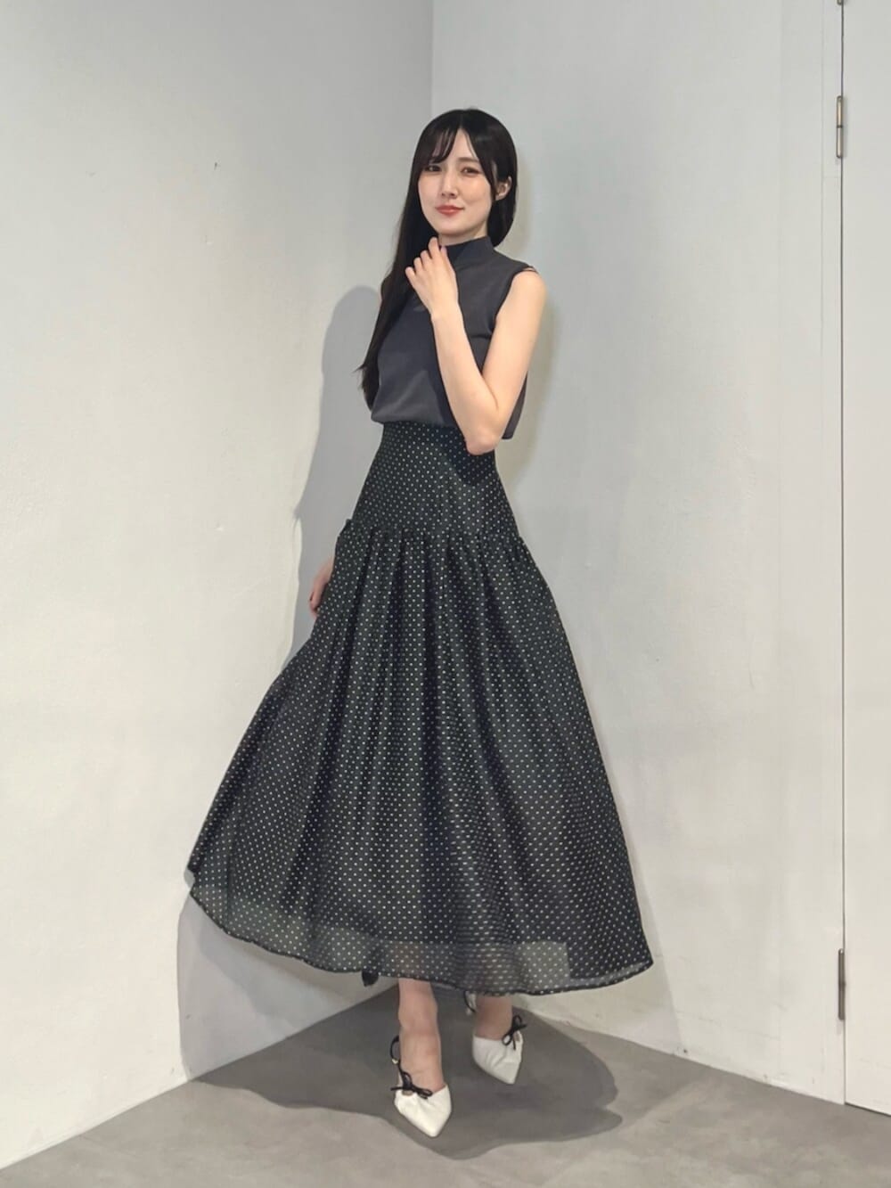 ホワイト系のサンダル、ブラック系のワンピースを着用したレディースの夏コーディネートの3枚目の写真