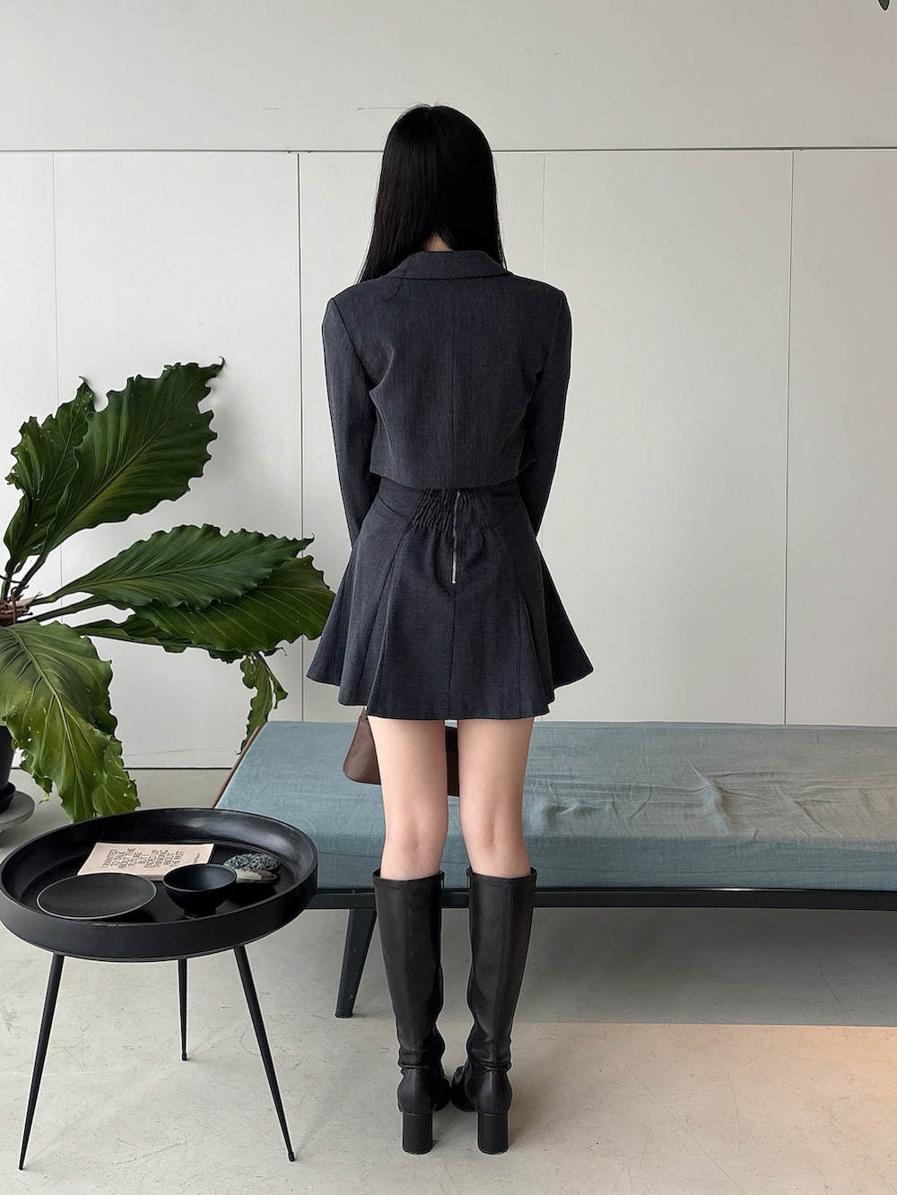 ブラウン系のブーツ、グレー系のテーラードジャケット、グレー系のスカートを着用したレディースの冬コーディネートの3枚目の写真