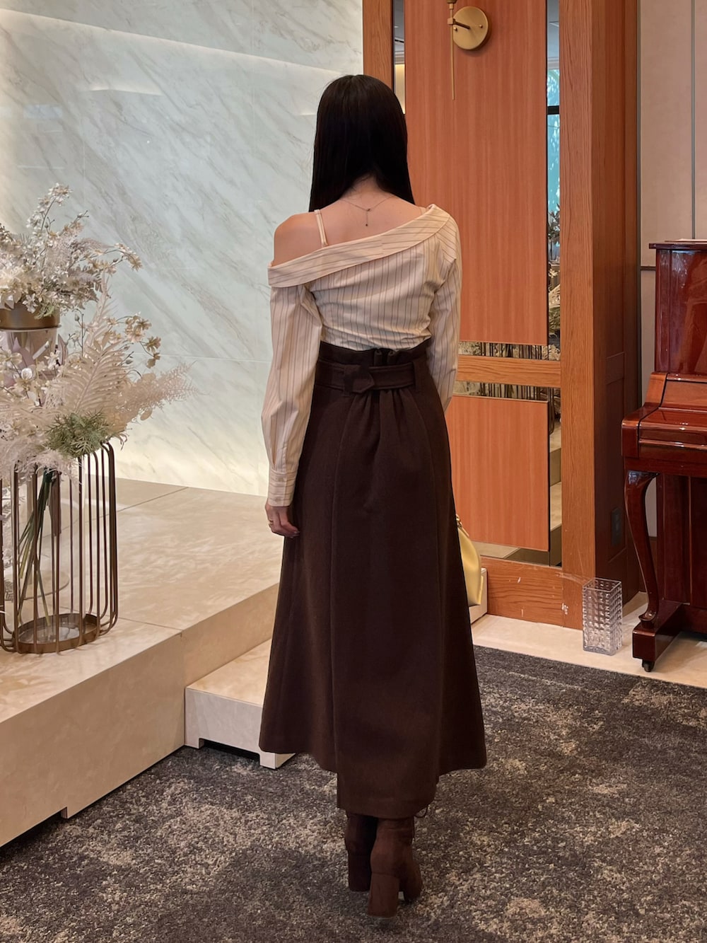 ブラウン系のブーツ、ブラウン系のスカート、イエロー系のショルダーバッグを着用したレディースの冬コーディネートの4枚目の写真