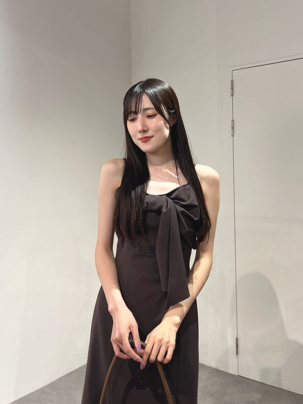ブラウン系のハンドバッグ、ブラウン系のパンプス、ブラック系のカーディガン/ボレロを着用したレディースの夏コーディネートの10枚目の写真