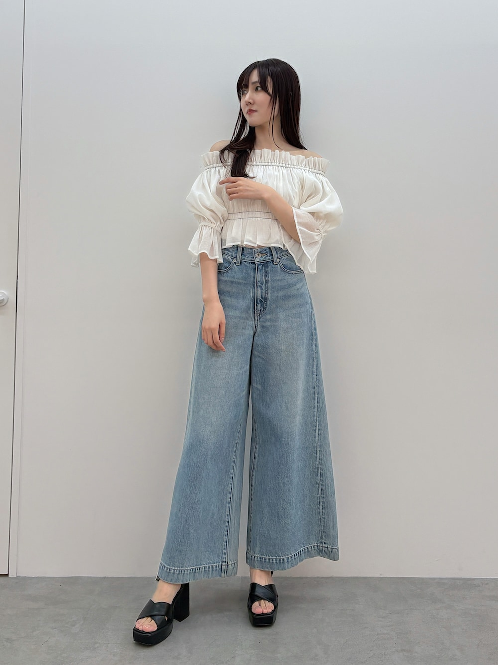 ホワイト系のシャツ/ブラウス、ブルー系のデニムパンツ、ブラック系のサンダルを着用したレディースの春コーディネートの2枚目の写真