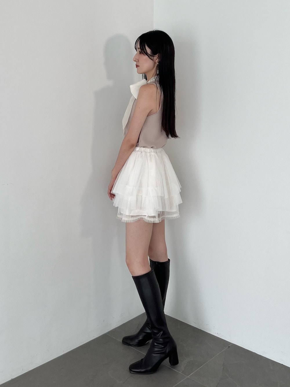 ホワイト系のスカート、ピンク系のニット/セーター、ブラウン系のブーツを着用したレディースの夏コーディネートの6枚目の写真