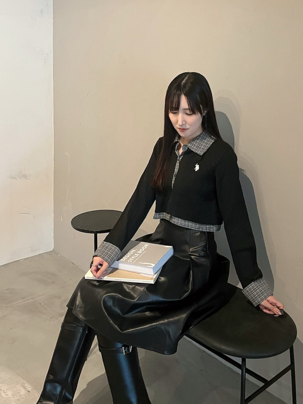 ブラック系のスカート、ブラック系のカーディガン/ボレロ、ブラック系のブーツを着用したレディースの秋コーディネートの3枚目の写真