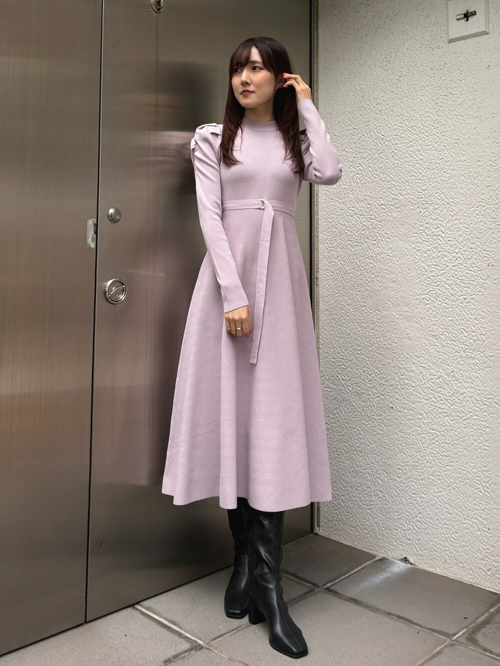 パープル系のワンピース、ブラック系のブーツを着用したレディースの冬コーディネートの2枚目の写真
