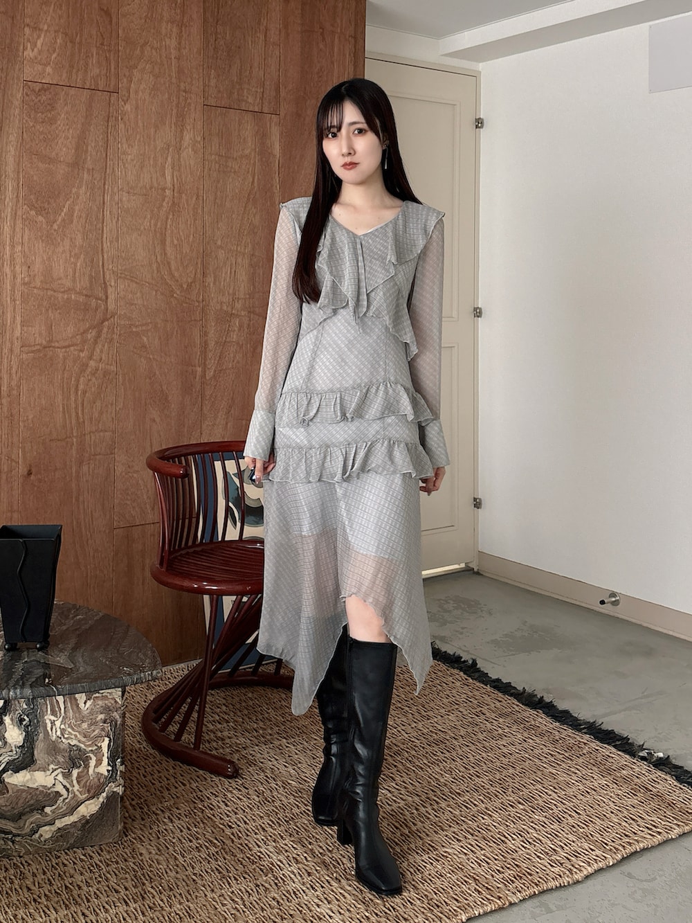 グレー系のワンピース、ブラック系のブーツを着用したレディースの冬コーディネートの2枚目の写真