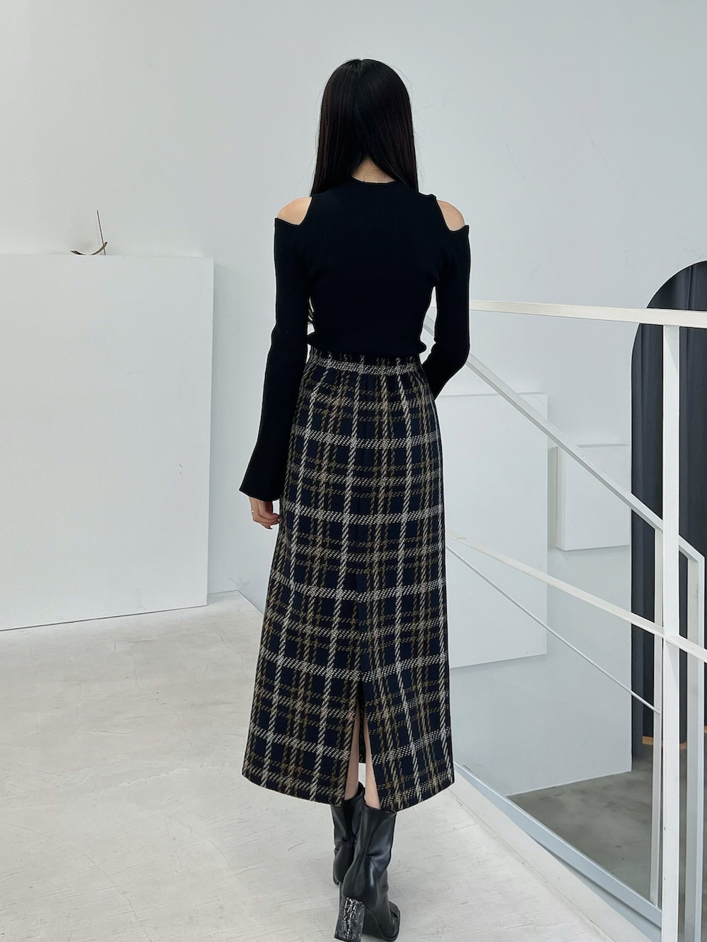 ブラック系のブーツ、ブルー系のスカート、ブラック系のニット/セーターを着用したレディースの春コーディネートの3枚目の写真