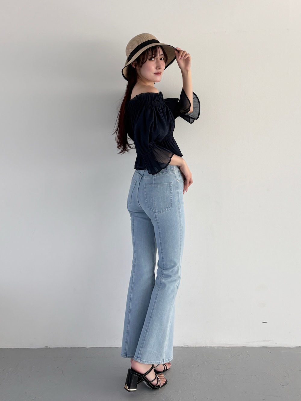 ブルー系のデニムパンツ、ブラック系のサンダル、ブルー系のシャツ/ブラウスを着用したレディースの春コーディネートの2枚目の写真
