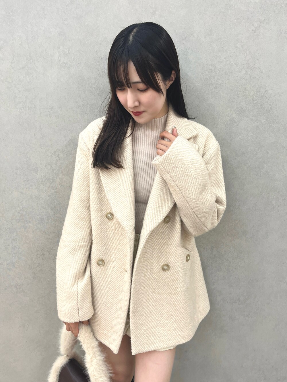 ベージュ系のテーラードジャケット、ベージュ系のニット/セーター、ブラウン系のブーツを着用したレディースの秋コーディネートの4枚目の写真