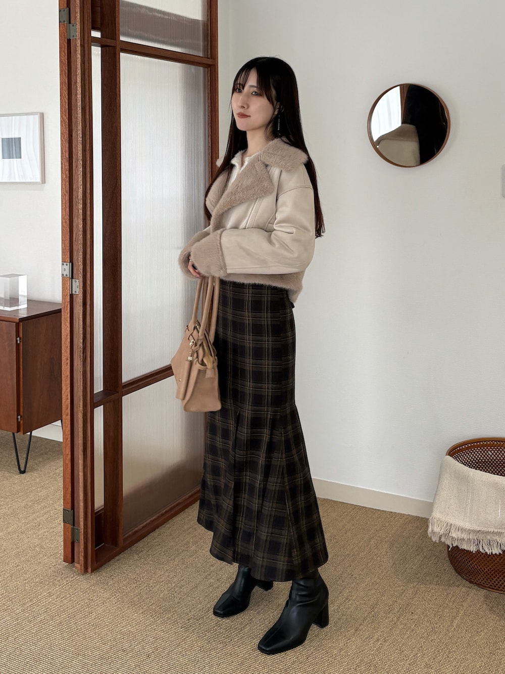 ホワイト系のカーディガン/ボレロ、ベージュ系のハンドバッグ、ブラック系のブーツを着用したレディースの冬コーディネートの3枚目の写真