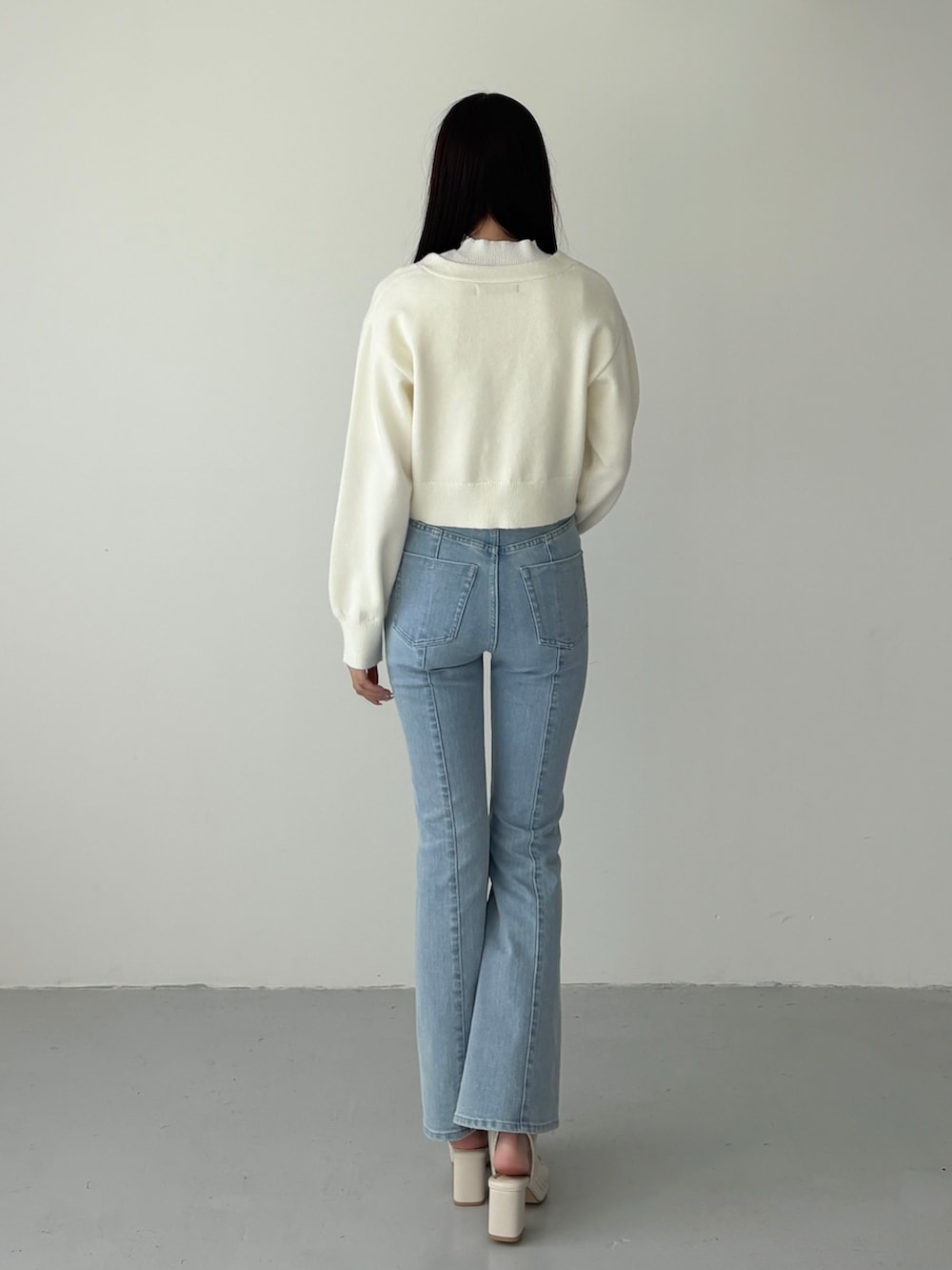 ホワイト系のカーディガン/ボレロ、ホワイト系のニット/セーター、ブルー系のデニムパンツを着用したレディースの冬コーディネートの3枚目の写真