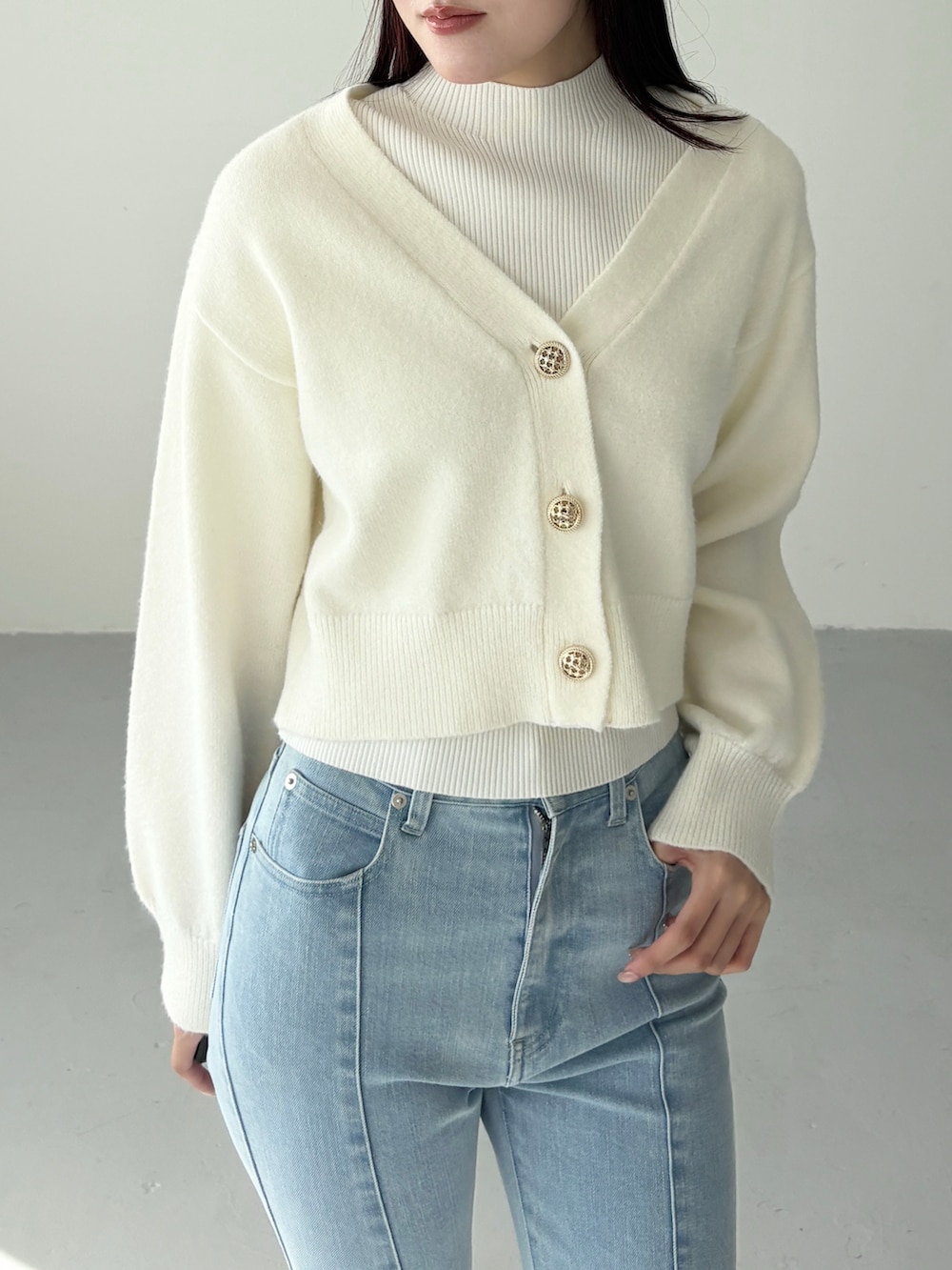 ホワイト系のカーディガン/ボレロ、ホワイト系のニット/セーター、ブルー系のデニムパンツを着用したレディースの冬コーディネートの4枚目の写真