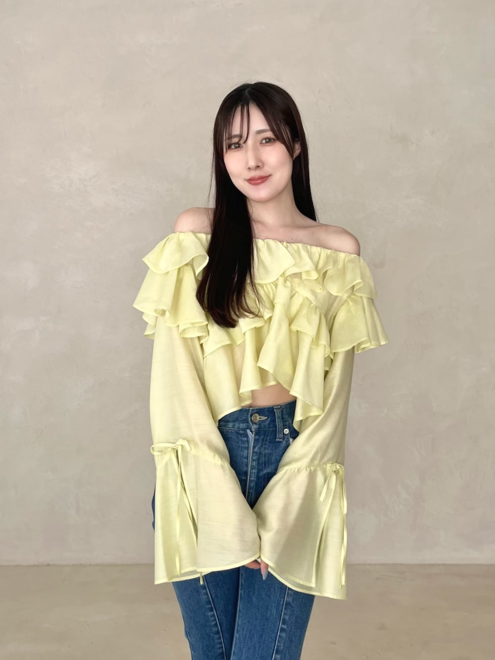 ブルー系のデニムパンツ、ブラウン系のローファー、イエロー系のシャツ/ブラウスを着用したレディースの夏コーディネートの2枚目の写真