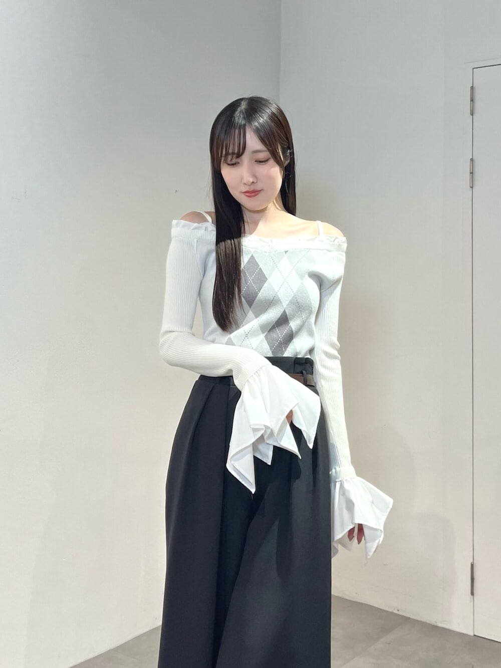 ブラック系のその他パンツ、ホワイト系のサンダル、ホワイト系のニット/セーターを着用したレディースの秋コーディネートの5枚目の写真