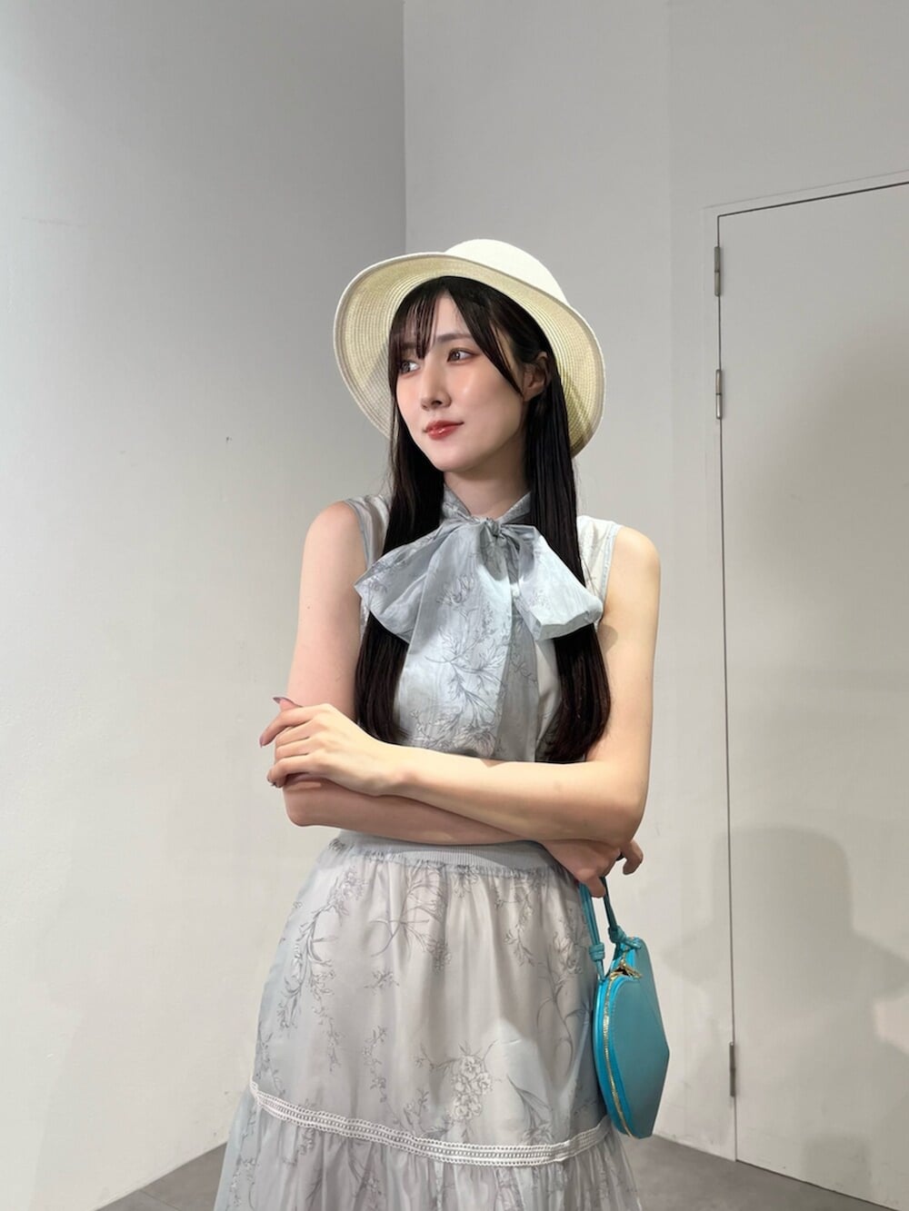 グリーン系のショルダーバッグ、ホワイト系のサンダル、ブルー系のワンピースを着用したレディースの夏コーディネートの5枚目の写真