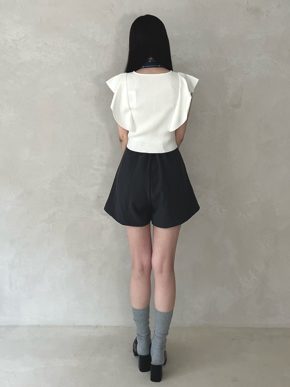 グレー系のその他パンツ、ブラック系のシューズ、ホワイト系のニット/セーターを着用したレディースの夏コーディネートの5枚目の写真