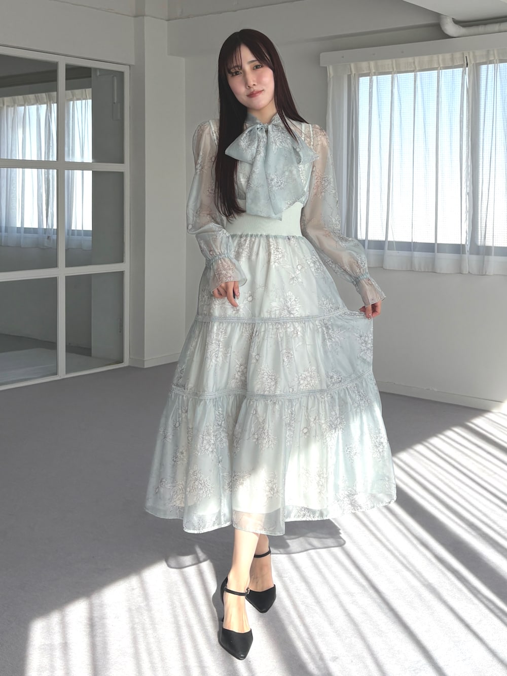 ブラック系のパンプス、グリーン系のワンピースを着用したレディースの春コーディネートの3枚目の写真