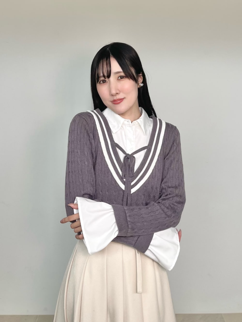 ブラウン系のブーツ、ホワイト系のスカート、パープル系のニット/セーターを着用したレディースの秋コーディネートの10枚目の写真