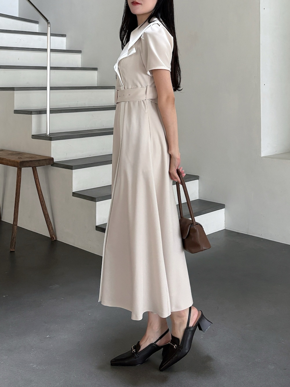 ベージュ系のワンピース、ブラウン系のハンドバッグ、ブラウン系のパンプスを着用したレディースの春コーディネートの3枚目の写真