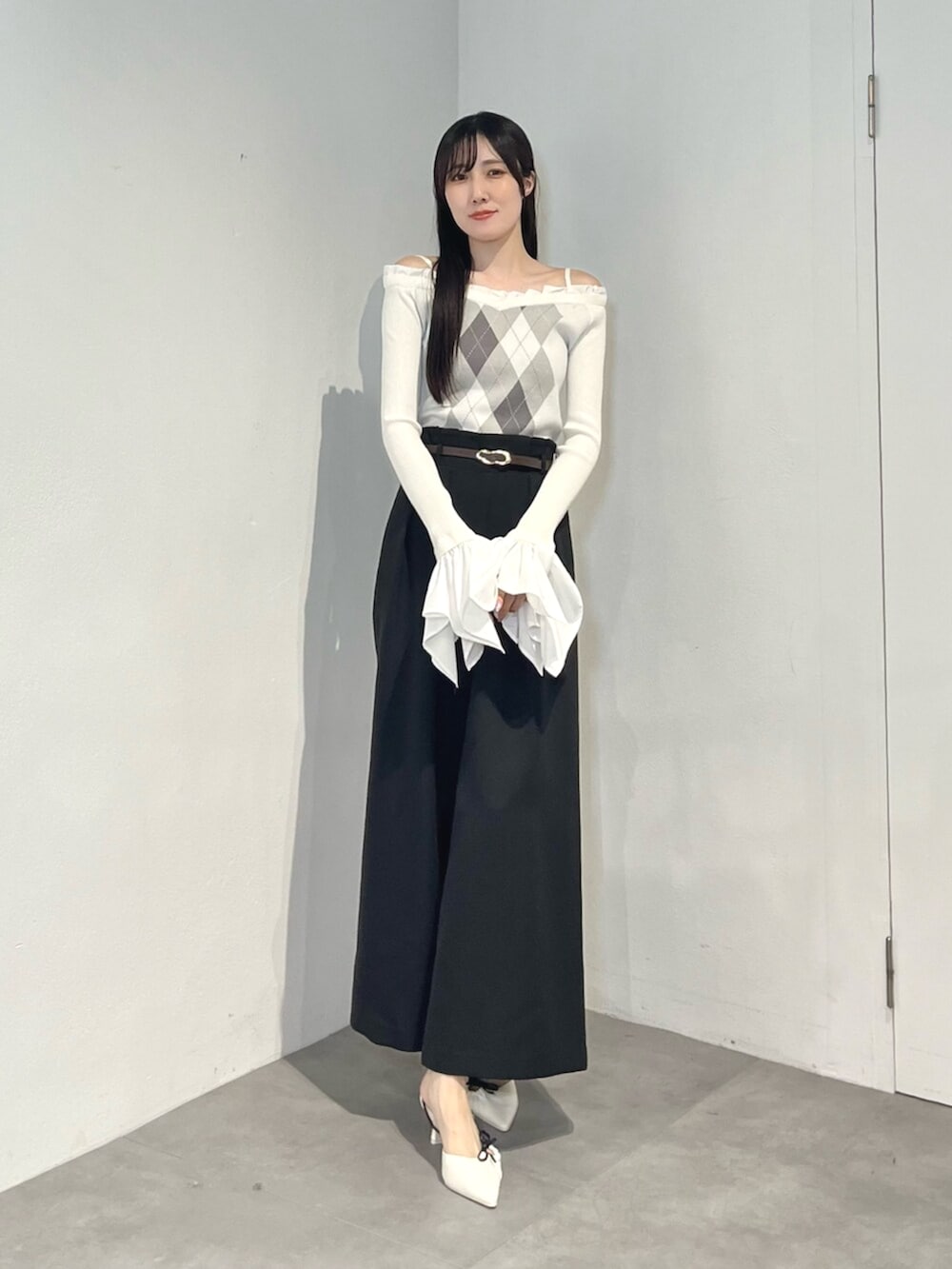 ブラック系のその他パンツ、ホワイト系のサンダル、ホワイト系のニット/セーターを着用したレディースの秋コーディネートの2枚目の写真